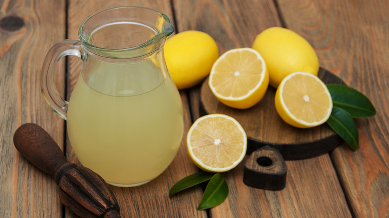 pitcher of fresh squeezed lemon juice with lemons