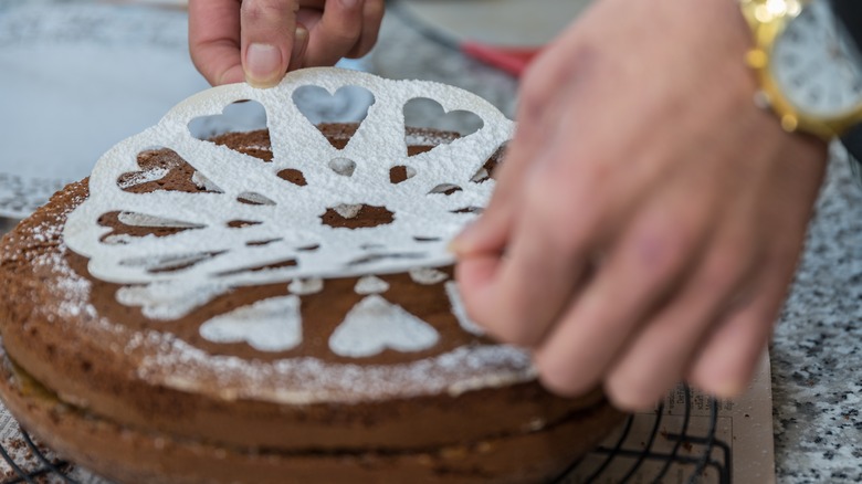 Person picking up cake stencil