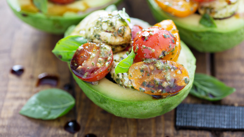 Avocado-stuffed caprese wooden surface