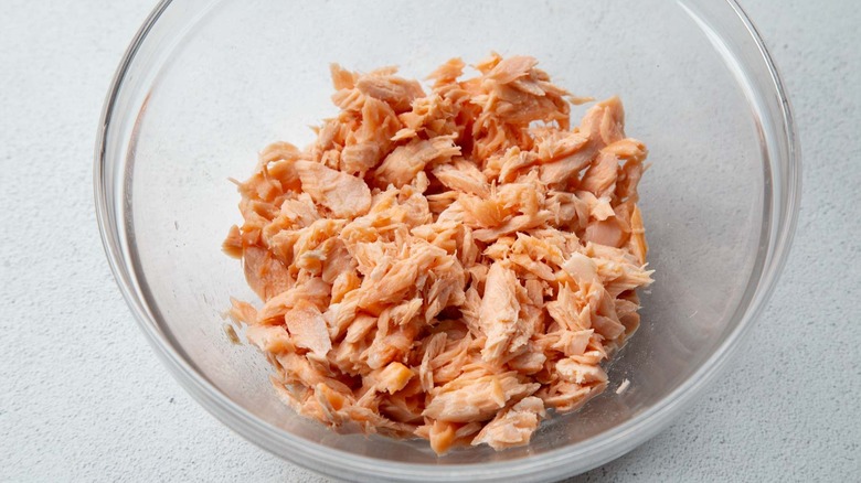 Flaked cooked salmon in a clear bowl