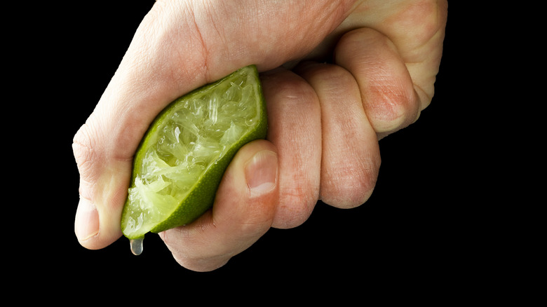 hand squeezing a lime wedge