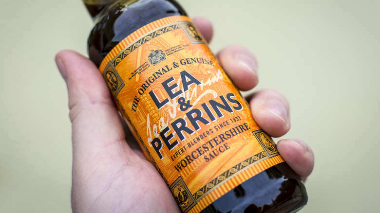 hand holding a bottle of Worcestershire sauce