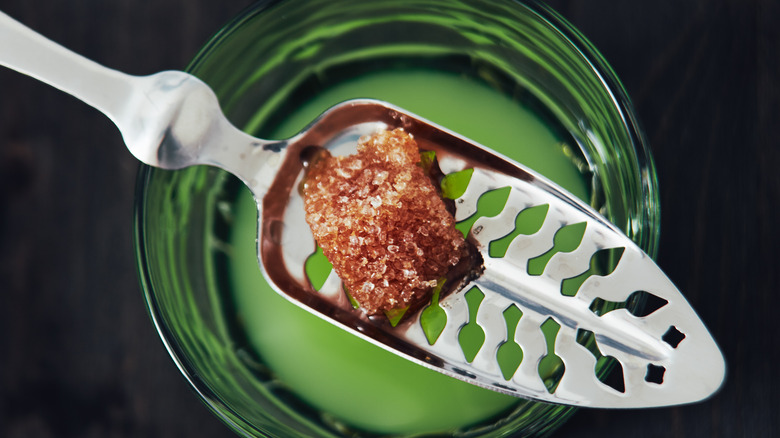 glass of absinthe with water and sugar cube