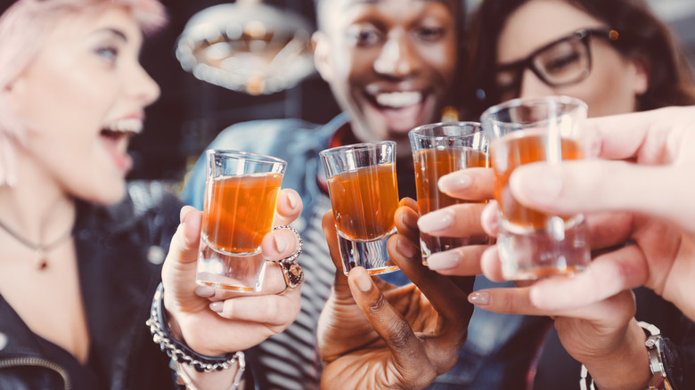 friends doing shots of brown liquor