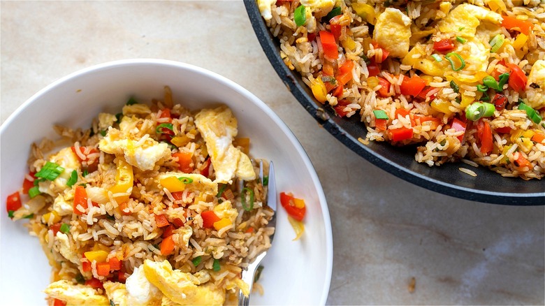 Top-down view of two plates of fried rice with scrambled eggs