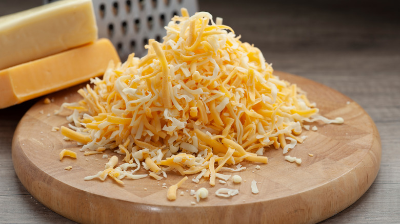Pile of shredded cheese on wooden tray