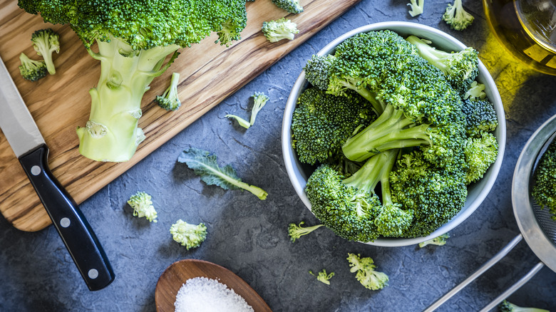 A head of broccoli being cut into florets