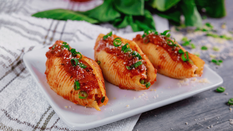 Three stuffed shells on a white plate