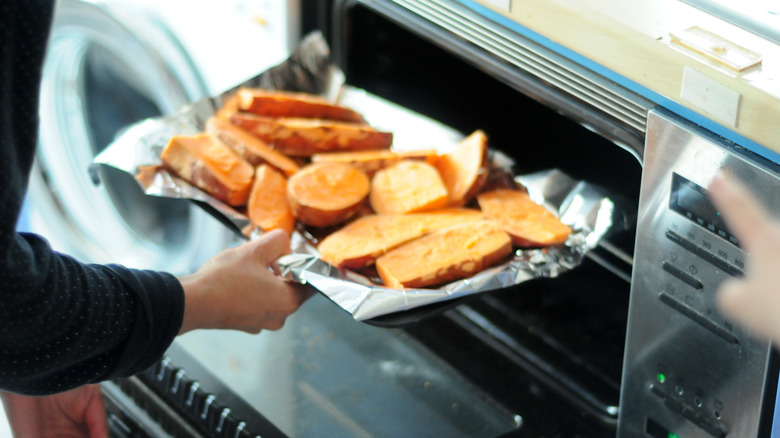 Putting sweet potatoes into the oven