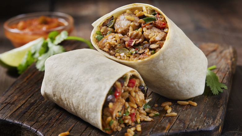 Halved burrito on wooden board