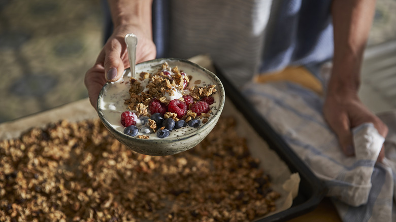 Person holding bowl of granola.