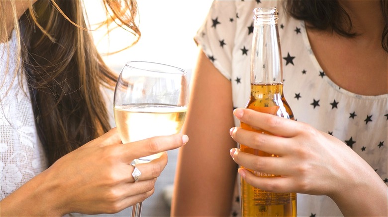 Hands holding beer and white wine