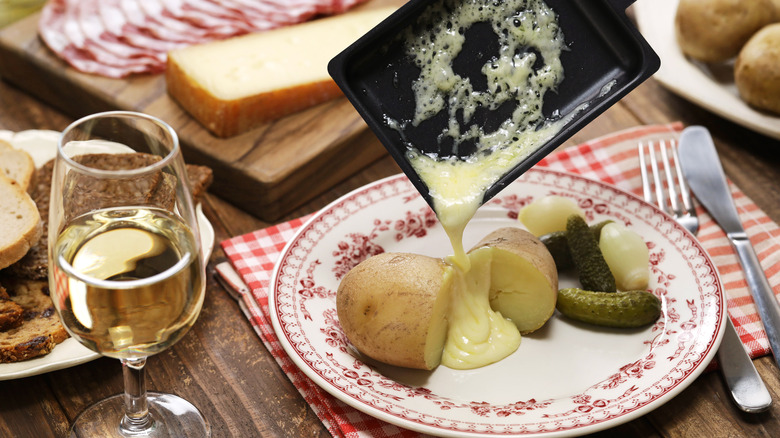 raclette poured over potato, pickle, onion