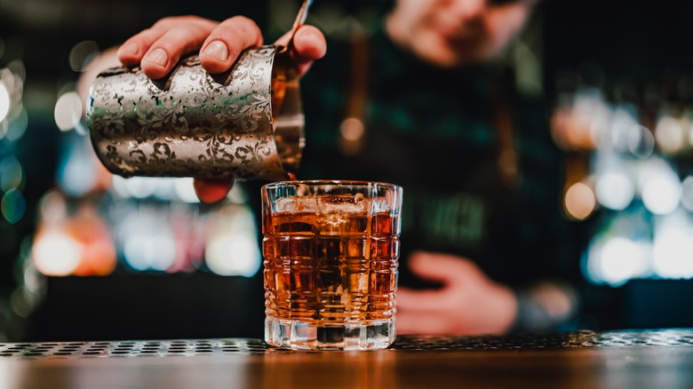 Bartender straining whiskey cocktail