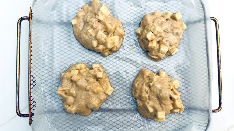 uncooked apple fritters in air fryer basket