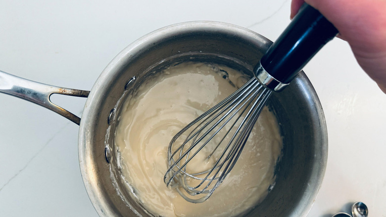 hand whisking ingredients in bowl