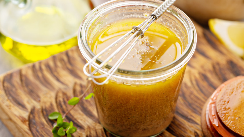 bowl of marinade, with olive oil, lemon, spices, and a whisk