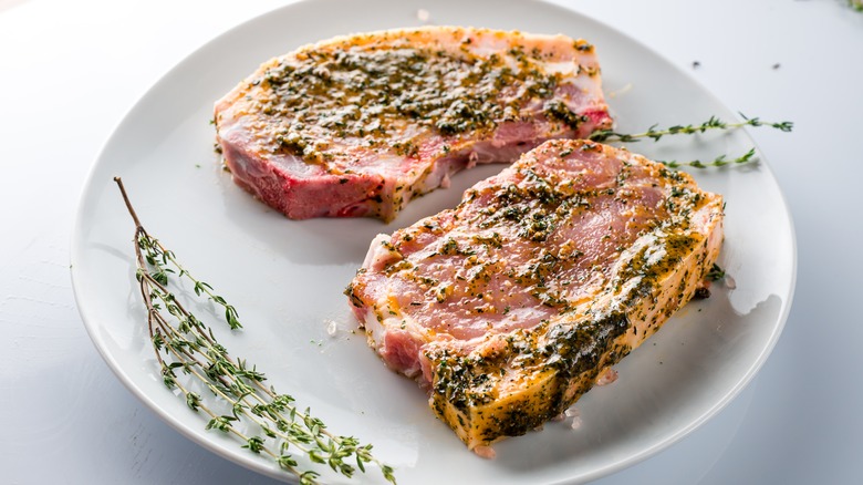 Pork chops marinating on plate