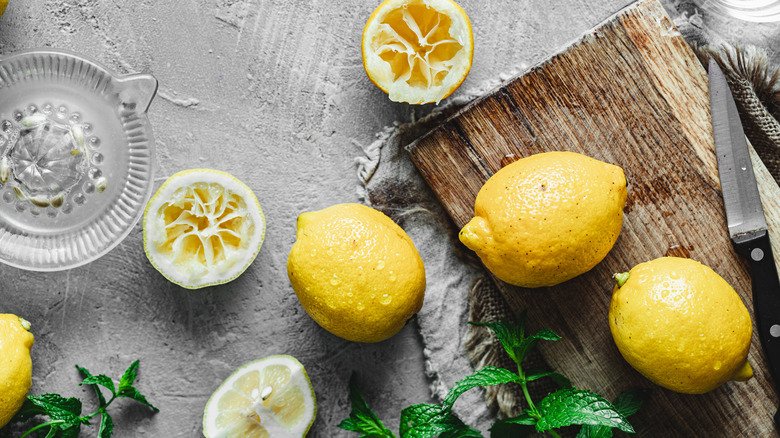 Lemons and mint sprigs on cutting board