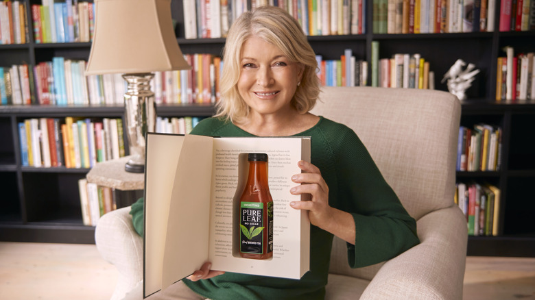 Martha Stewart holds book and tea bottle