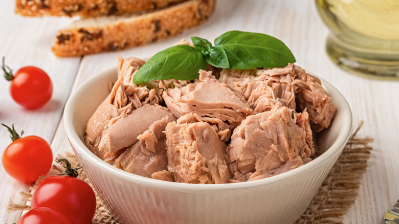 tuna in a bowl topped with sprig of basil