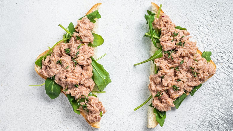 tuna mixed with basil on two halves of bread slice