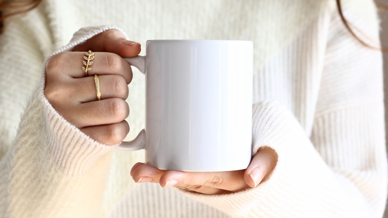 A person holds a cup of coffee