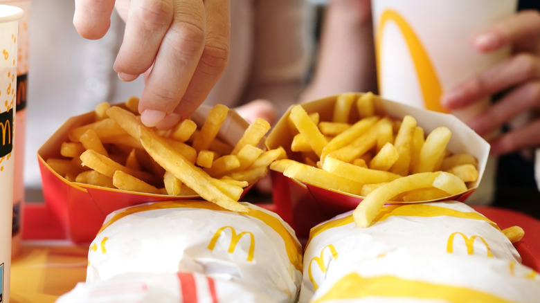 A person trying out Mc Donald's French fries at one of its outlets.