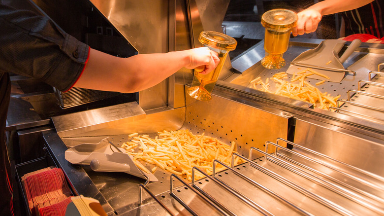 sprinkling salt on fries