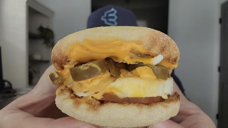 YouTuber holding up Cheesy Jalapeño Sausage Egg McMuffin