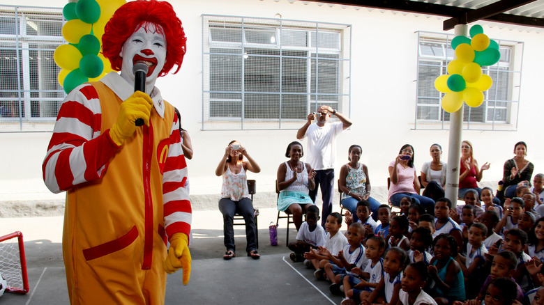 Ronald McDonald onstage with microphone