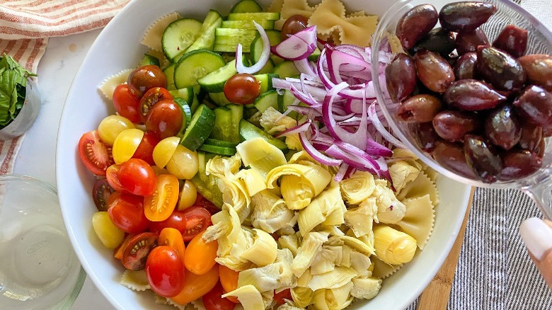mixing Mediterranean pasta salad 