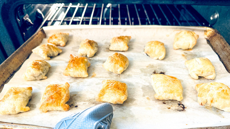 cooked pastries with gloved hand