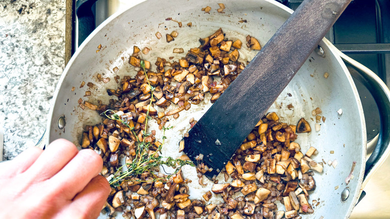 hand with pan of mushrooms