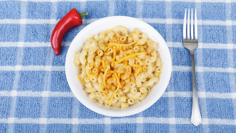 A bowl of mac and cheese with cayenne powder