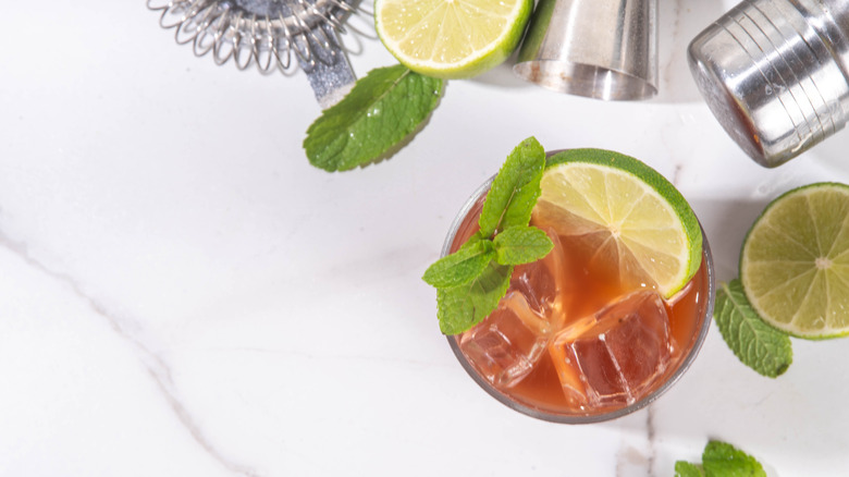 A cocktail on a table with bartending equiment