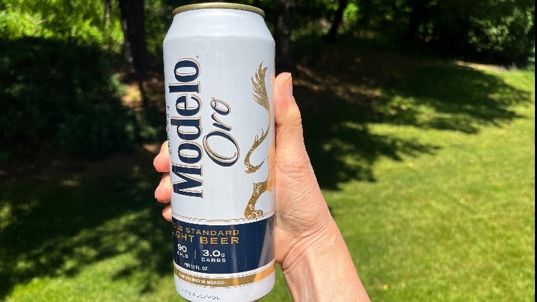 Hand holding Modelo Oro can