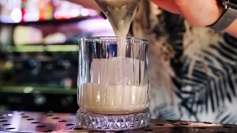 White cocktail poured into glass