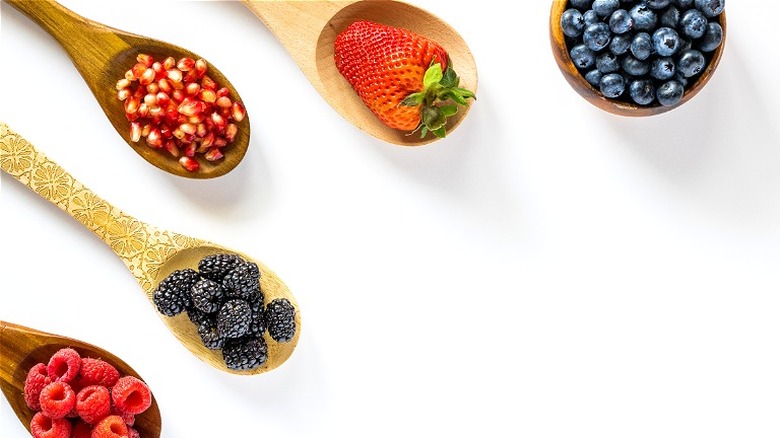 Various fruits on wooden spoons