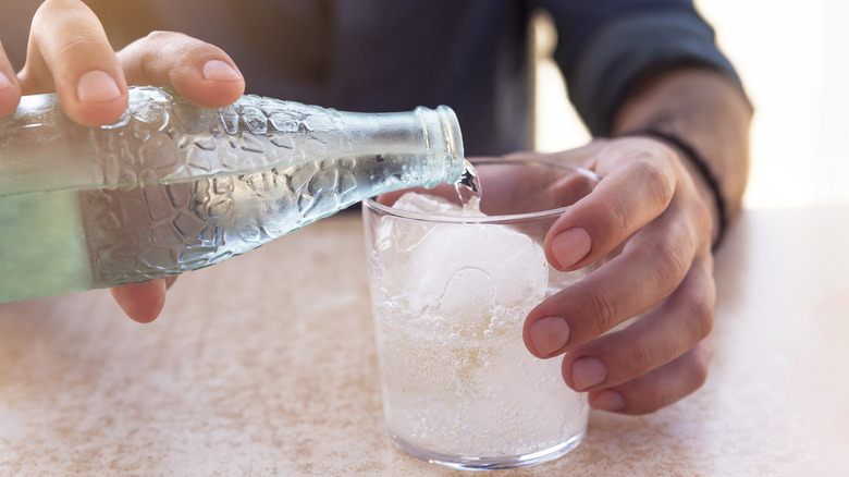 pouring soda water into glass