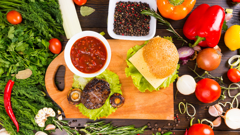 A burger surrounded by toppings