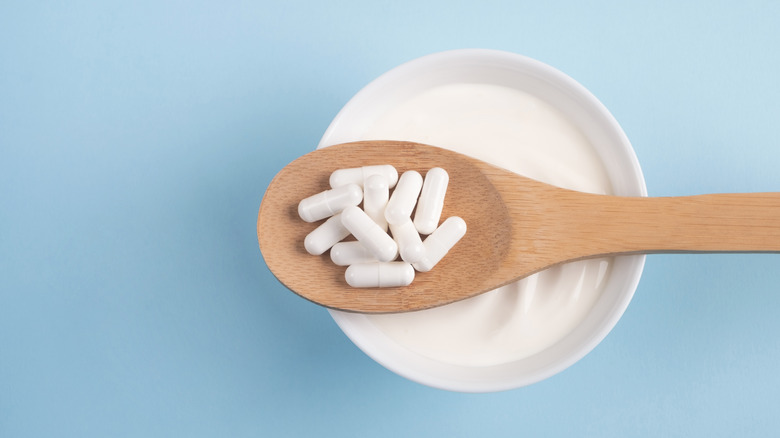 Probiotic supplements on wooden spoon