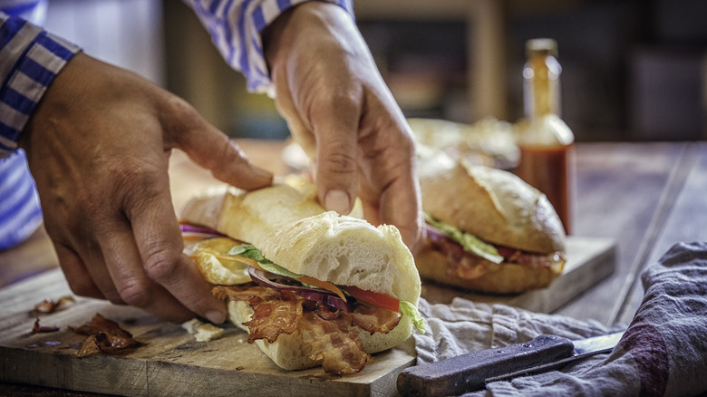 person making a baguette sandwich