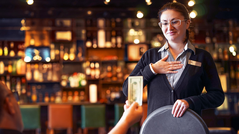 Waitress receiving a cash tip from a diner