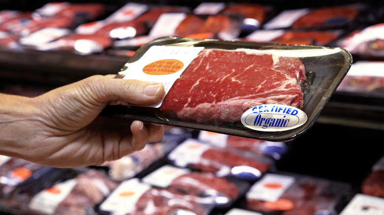 hand holding tray of beef