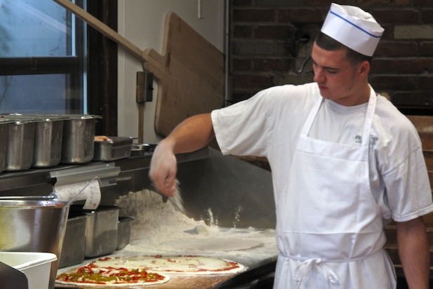 One of the fifty-odd trained pizzaiolos working his craft at Frank Pepe's "The Spot" in New Haven.