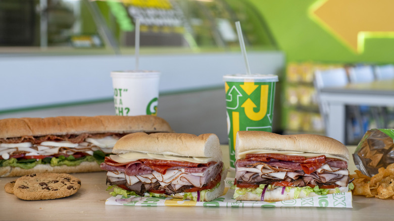 Subway sandwiches, cookies, and drinks on a table in the restaurant