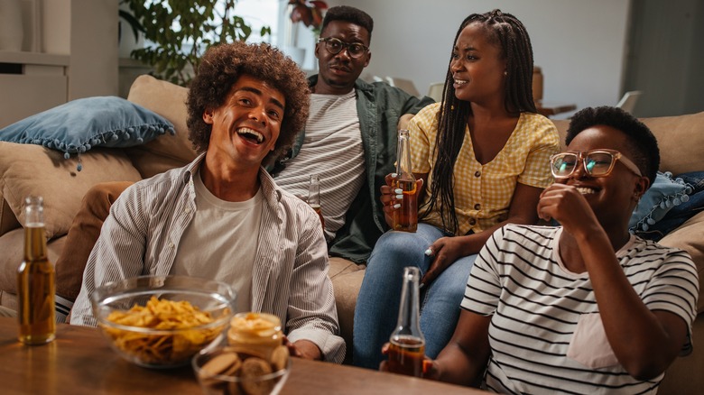 People drinking alcohol at home smiling