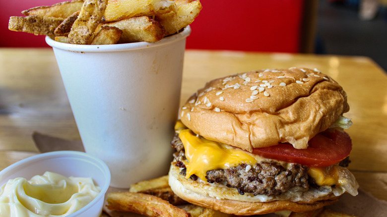 Cheeseburger and a cup of fries with mayo on the side