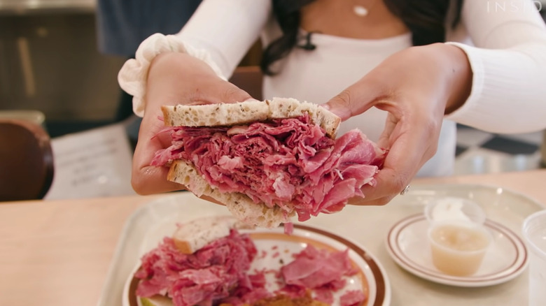 Woman holding corned beef sandwich